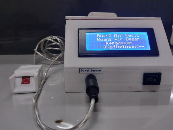 A white device with a screen and wires

Description automatically generated